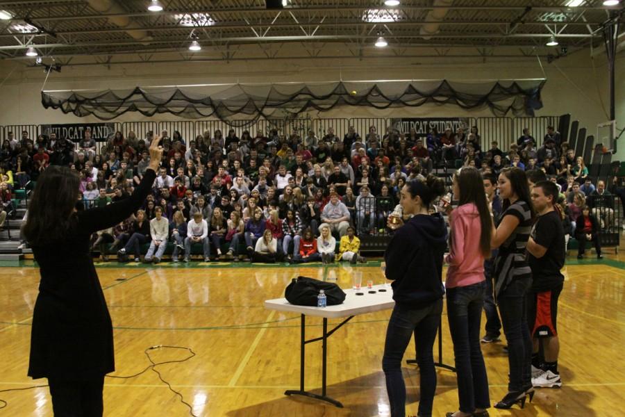 Debbie Allen and De Soto High School students simulate how easy it is to consume a deadly amount of alcohol by quickly drinking 6 oz water bottles. 