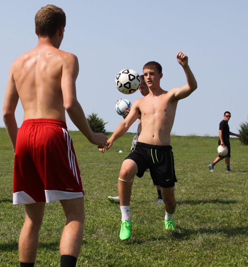 Seniors Kyle Moose and Travis Hodge warmup at practice on August 25,2015.