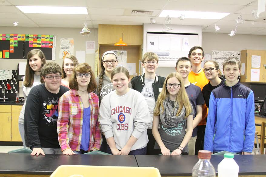 Science Olympiad team members line up and smile for the camera.