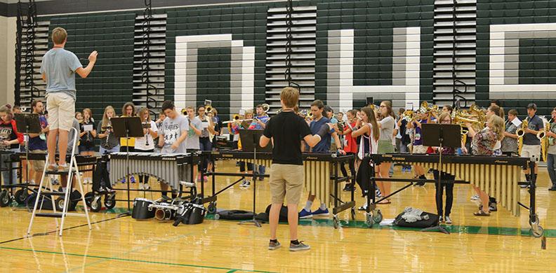 Drum majors Evan Sullivan and Zach Yarbrough conduct the De Soto High School marching band at rehearsal on Aug. 26.