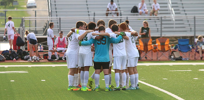 The varsity boys' soccer starters huddle before the start of the game on Aug. 30.