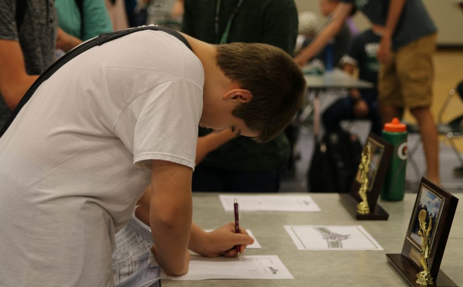 A freshman boy signs up for tennis team at activity fair on Aug. 30.