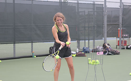 During a practice Zoller feeds balls to JV tennis players as they prepare for their upcoming match.