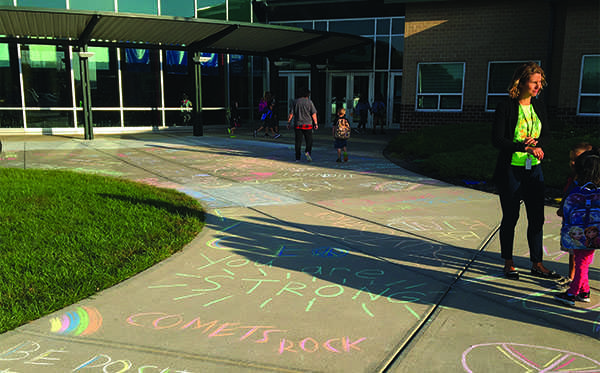 Starside students walk into school over the CatPRIDE members' sidewalk chalk artwork for Peace Week. CatPRIDE students who volunteered included seniors Emma Bascom, Jackie Kennard and Kirstin Cuba, junior Sam McGuire and freshman Issa Sullivan.