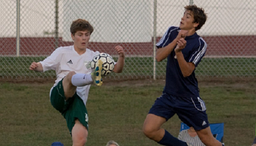 Sophomore Daniel Apple volleys the ball past a Eudora defender on Oct. 3.