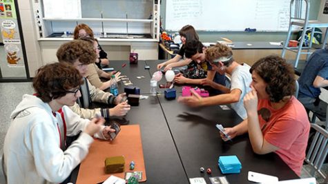 Students sit around a table at Magic the Gathering club in Sixta's room on Oct 6, ready to play Magic and socialize