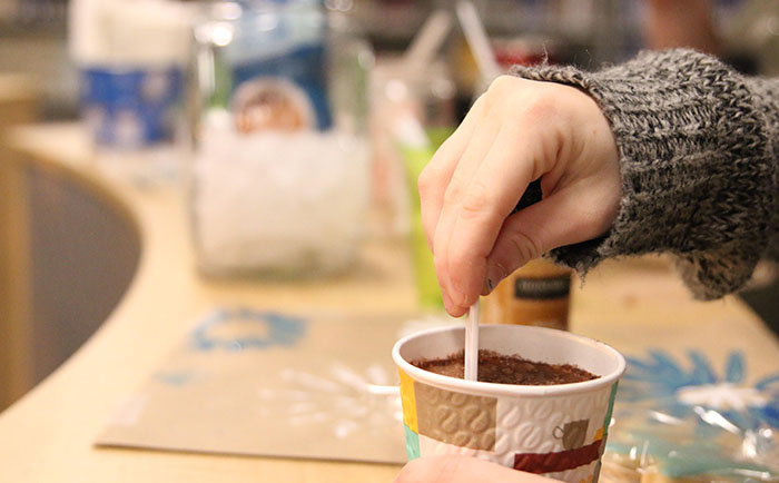 A student stirs his or her cup of hot chocolate on Tuesday, Dec. 13, as part of a fundraiser done by DHS' marketing class. 