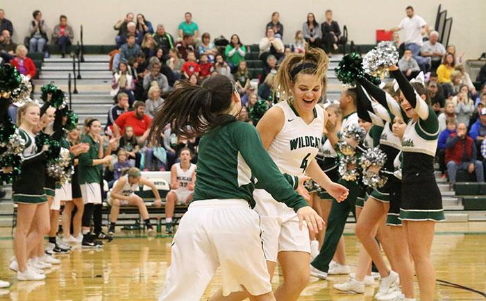 Juniors Mariah Grizzle and Mara Montgomery high five as they run onto the court for the DHS girls' home opener. 