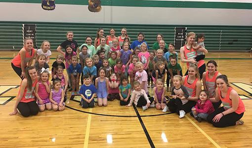 Junior dancers pose with the Diamonds after practicing at the junior dance clinic.