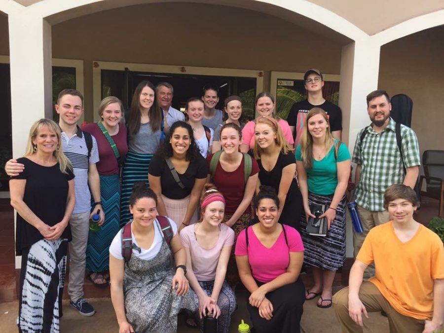 The mission group poses for a picture outside a housing unit.  