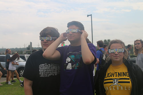 Seniors Micah Faulds, Johnny Meehan and Reaghan Wharff model their eclipse glasses on Aug. 21. Photo by Rylee Wilson.