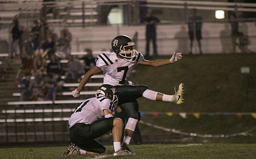 Senior Connor Strouse holds the ball while senior Ethan Rodriguez kicks for the point after in Louisburg on Sept. 15. 