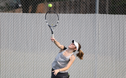 Junior Bailey Ramsdell serves to her opponent at Mill Valley during the tennis tournament.