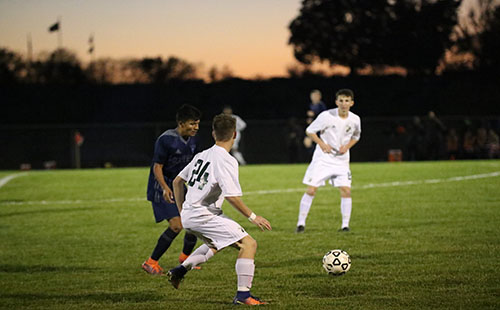 Senior Ben Lamar prepares to pass the ball to teammate, junior Carson Brier on Oct 24.