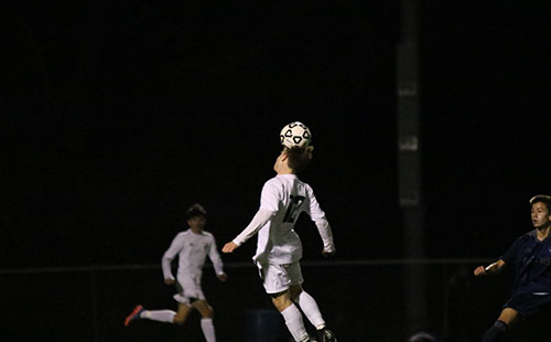 Sophomore James Henggeler heads the ball to pass it up the field on Oct 24.