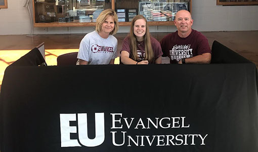 Senior McKenna Webber signs to play soccer at Evangel University with her parents, Jon and Cathy Webber, on Sept. 30.