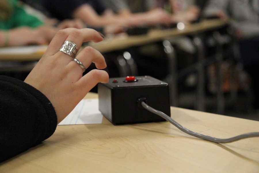 Junior Micaela Carillo's hand hovers over the buzzer in anticipation for the question at a scholars' bowl practice.