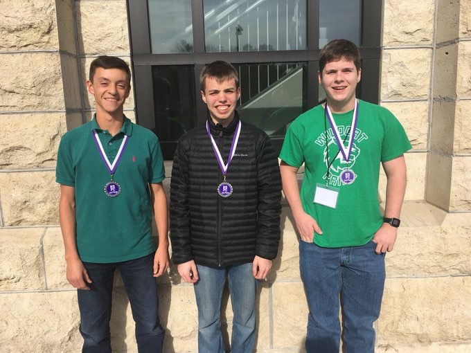 Seniors Cody Moose, Zach Deibert and Alex Webber pose outside of K-State with their medals on nov. 1