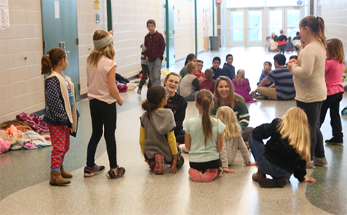 Juniors Lizzy Arnold and Caroline Whipple, both members of Student Council, laugh with Starside Elementary School students during the movie day hosted at DHS. 