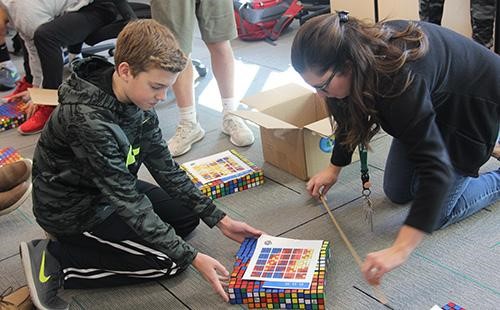 Freshmen Jake Facinelli works with teacher Inga Kelly to create Rubik’s cube art on Dec. 2nd