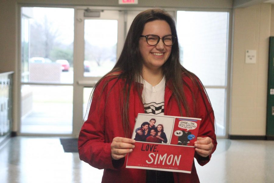 Senior Alysha Bell holds a sign for the popular new movie "Love, Simon," which features a gay teenager who struggles with coming out to his friends and family.