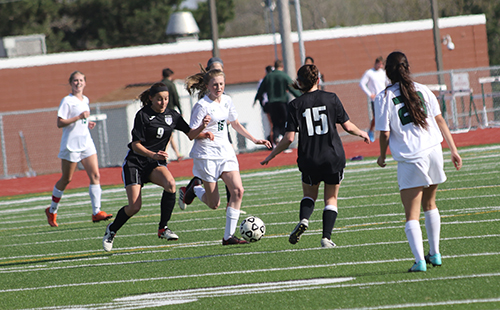 Freshmen Riley Padden dribbles through the Blue Valley Northwest defense in the Wildcats 1-0 win at home against on April 16.
