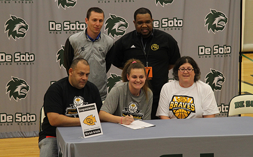 Surrounded by family and coaches, senior Mariah Grizzle signs her national letter of intent to play college basketball at Ottawa University on April 30.