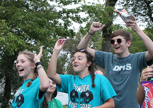 Juniors Corinne Daise, Maddy Mascareno and Colton Jones throw candy out to the crowd in downtown De Soto during the homecoming parade on Sept. 12th.
