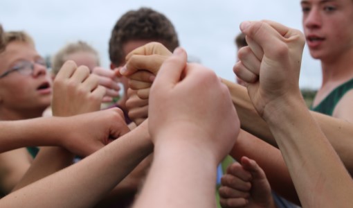 The boys' varsity cross country team prepares for their team chant minutes before the start of their race on Sept. 6.