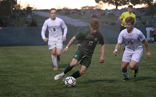 Junior forward James Henggeler dribbles past a Basehor-Linwood defender at the home soccer game on Sept. 25.