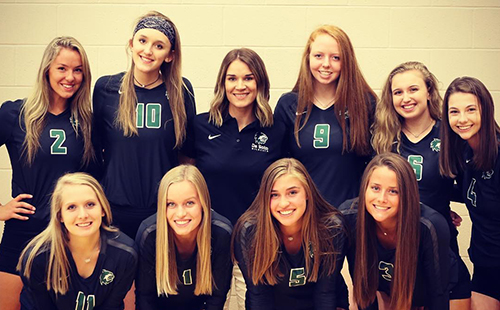 Coach Lindsay Hothan poses with the nine 2018 volleyball seniors during fall sports picture day Aug. 21.