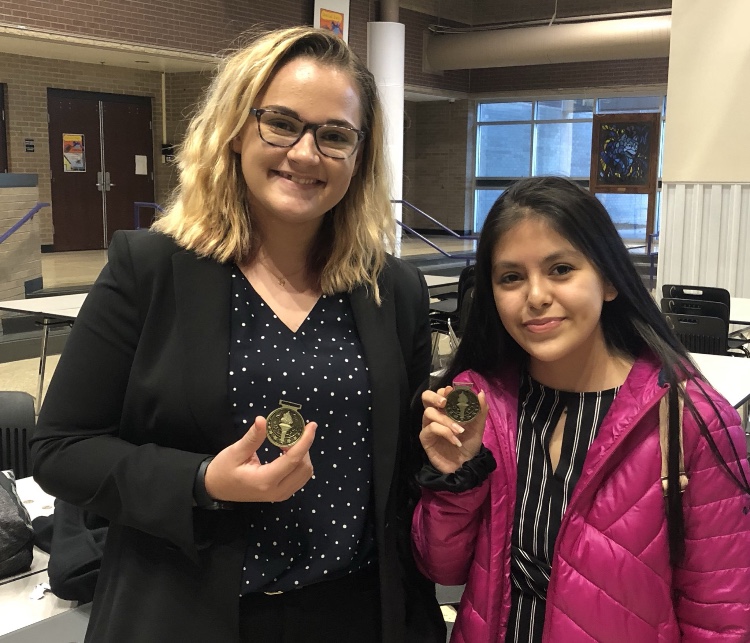 Junior Kate Tickle and freshman Deleana Marquez pose with their fourth-place medals at the Blue Valley Northwest novice debate tournament on Oct. 20.