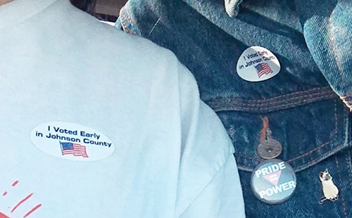 Senior Jacob Ward and his friend, Mill Valley High School senior Darlene Yanez take a picture of the stickers they received after voting early at  Okun Fieldhouse on Oct 29. 