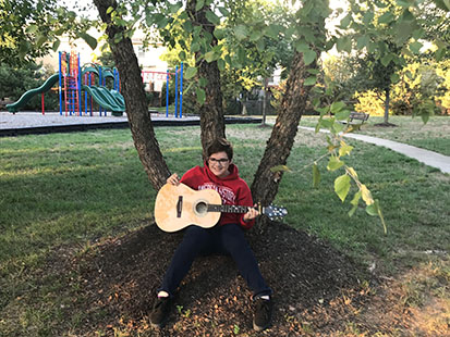 Sophomore Adam Kellogg poses with his guitar.