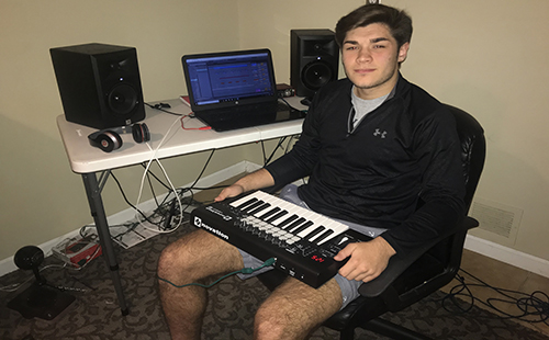 Senior Evan Sauro sits in front of his sound board where he writes raps and produces beats.