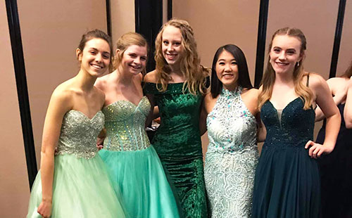 A group of De Soto High School students show off their dresses backstage of the Natalie M. Fashion Show on Feb 3. 