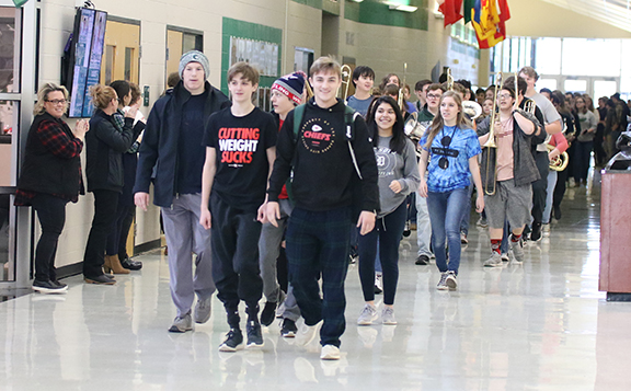 De Soto High School wrestlers Jackson Mocca, Zak Kalafut, Lane Warner and Luke Barger walk in front of the band during their State send-off on Thursday, Feb. 21. 