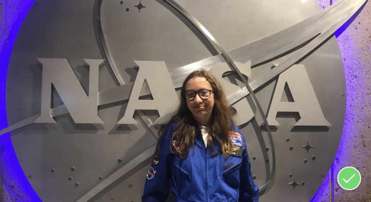 Sophomore Isabel Haake poses in front of the NASA logo while attending space camp in Huntsville, Alabama, in 2018.