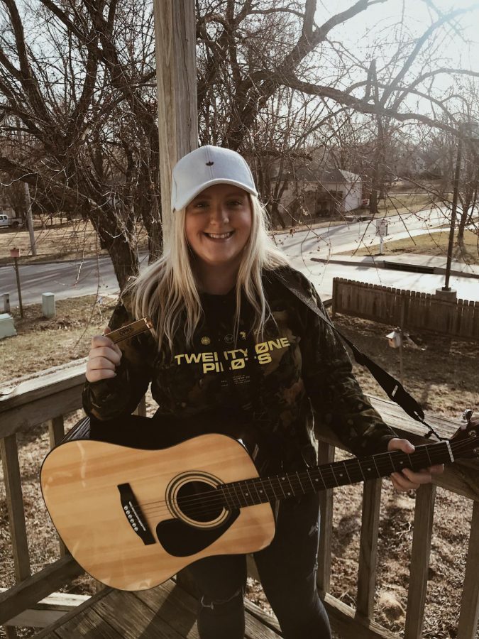 Junior Faythe Reeves poses for a picture with her guitar and new harmonica she got during her spring break trip to Nashville on March 18.
