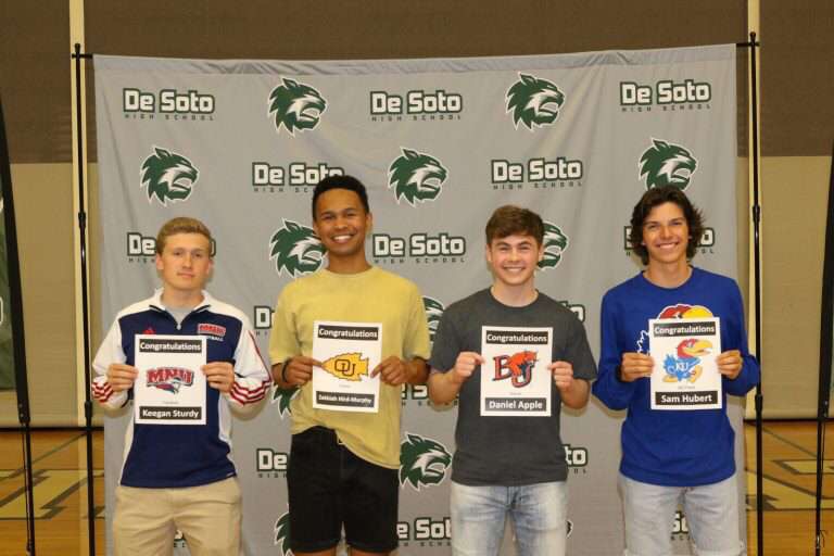 Seniors Keegan Sturdy, Zekkiah Hird, Daniel Apple, and Sam Hubert stand with their certificates at college signing April 17.