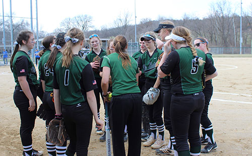 The softball team huddles together for a pregame talk before their games against Leavenworth High School on March 27. 
