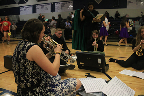 Senior Adriana Feener warms up in the gym with members of the trumpet quintet at Mill Valley High School before their performance on April 6, 2019.