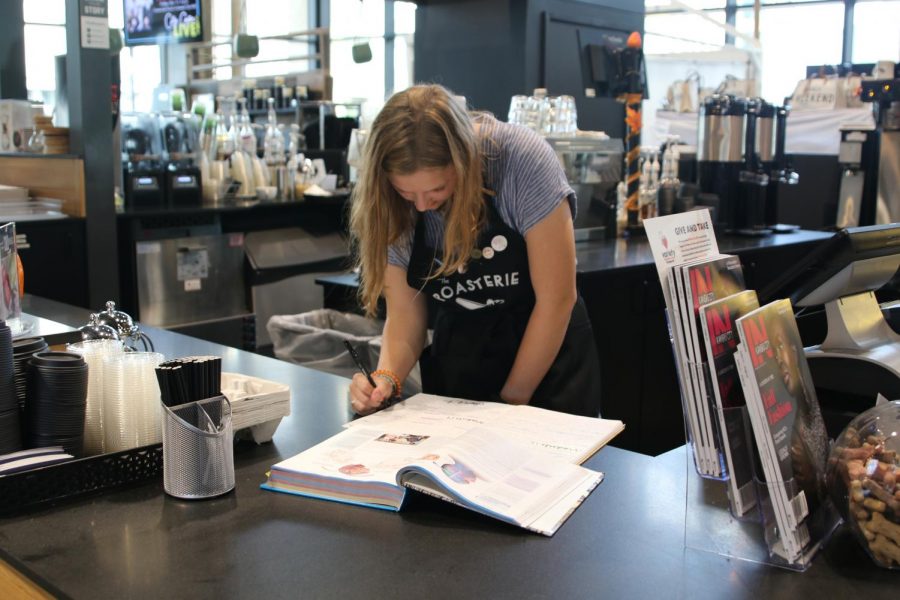 Senior Aspen Grieshaber works on her AP Psychology homework during her down time at work at the Lenexa Public Market on Sept. 25.
