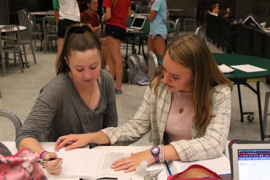 Senior student tutor Delaney Lecluyse helps junior Emma Brownell with her physics homework at Study Tables after school on Sept 4.