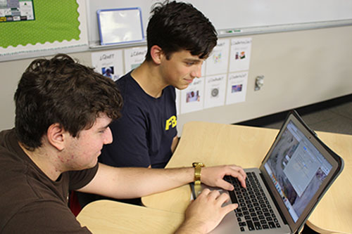 Senior Alex Bates assists a student with a technology problem relating to his Macbook on Sept. 9. 