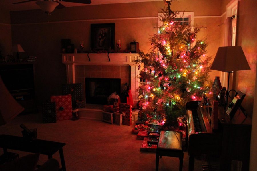 A Christmas tree is displayed with gifts surrounding.