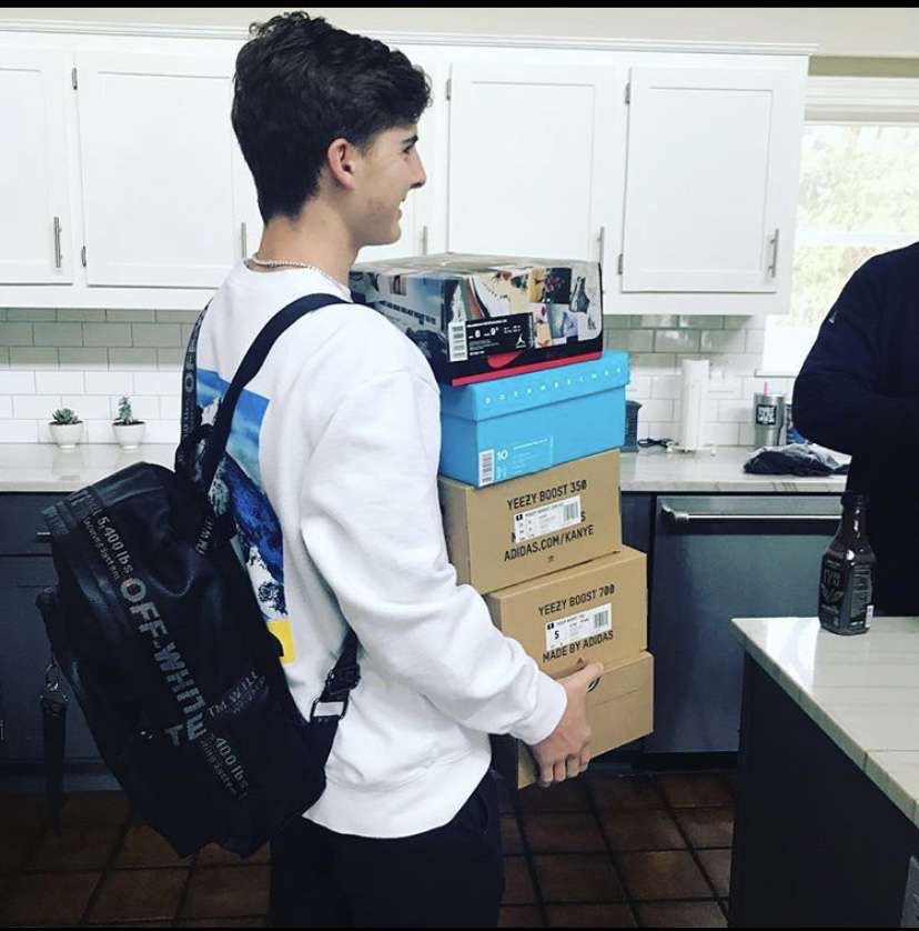 Junior Ben Harding prepares shoes that he has sold for shipment to his clients. 