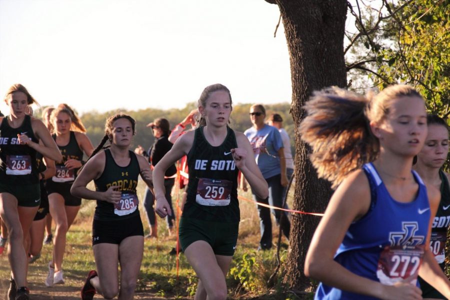 Senior Justine Wheeler races in a varsity girls 5K cross country meet. 