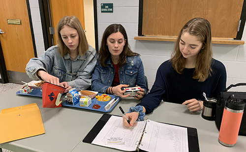 Sophomore Student Council Executives, Reagan Ames, Josie Butler and Brenna Johnson sell Winter Homecoming tickets at lunch on Feb. 6.