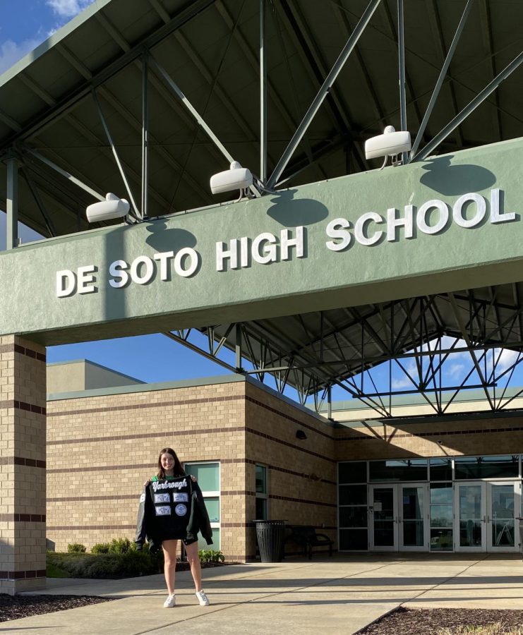 Junior Abi Yarbrough poses in front of De Soto High School for senior class present campaign photo.